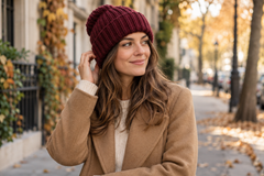 Femme portant un bonnet bordeaux et un manteau camel